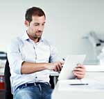 Mann tippt auf Tablet - Newsletter