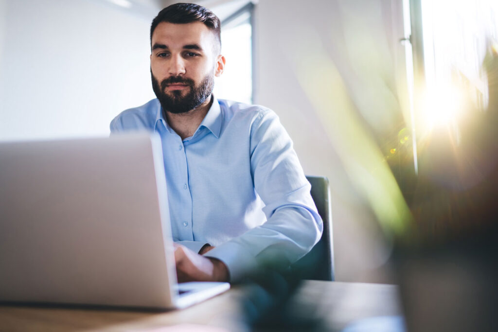 Ein Integrations- und API-Entwickler sitzt vor seinem Laptop und programmiert eine neue Schnittstelle.